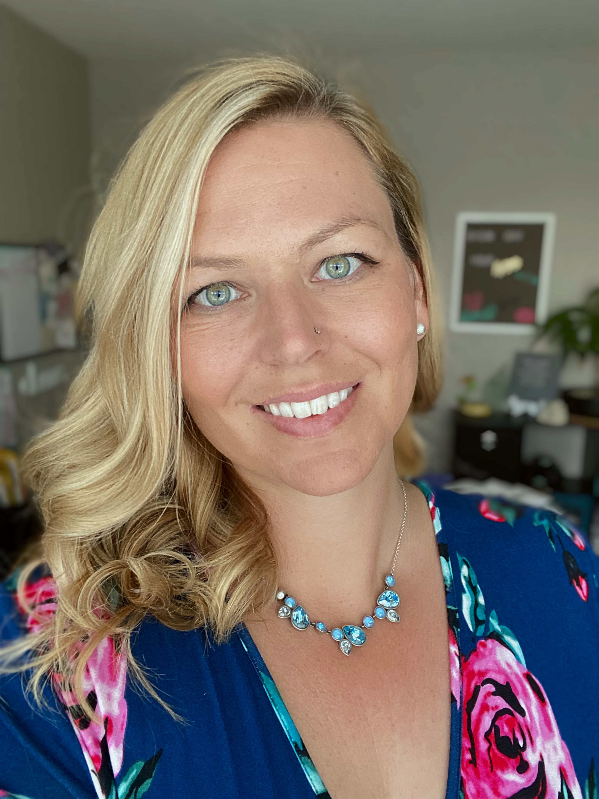Samantha smiling while holding a laptop, showing her approachable brand photographer personality