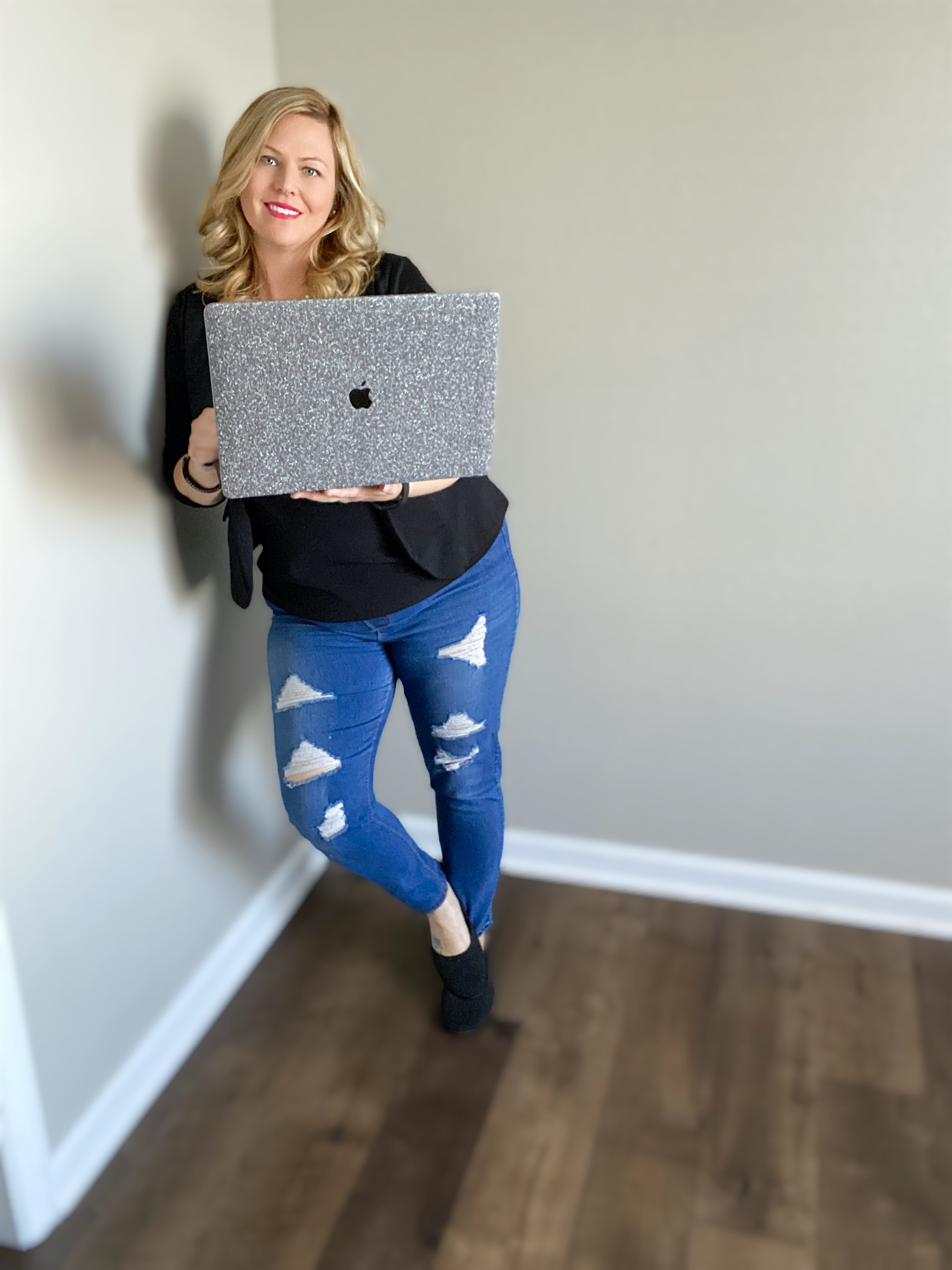 Samantha smiling while holding a laptop, representing her approachable and expert marketing style