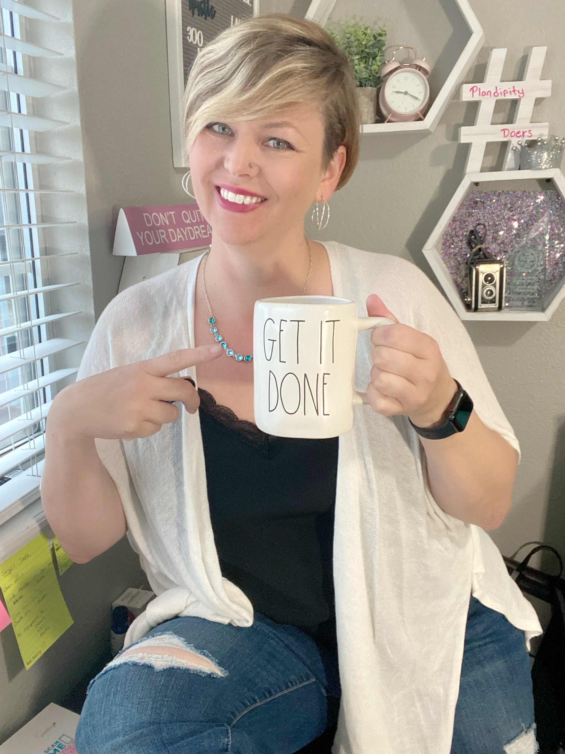 Samantha smiling and holding a coffee mug, sitting casually, representing her friendly and approachable coaching style