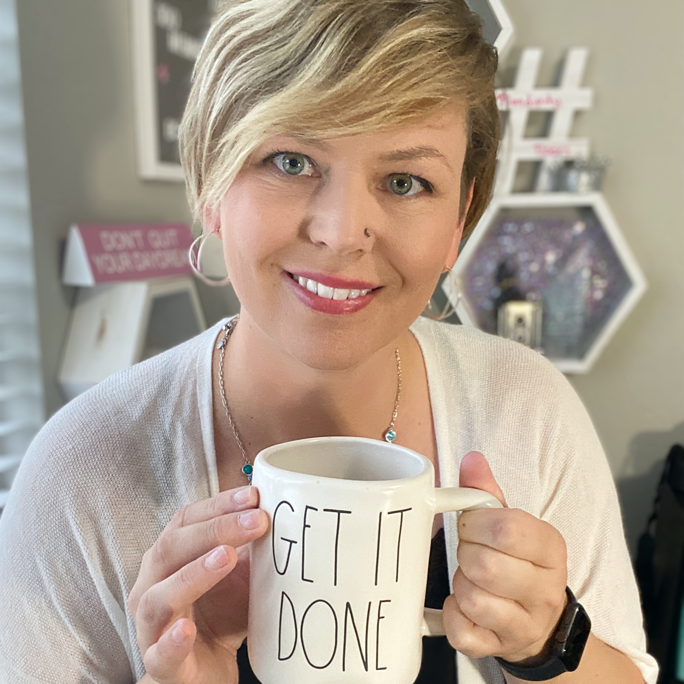 Samantha smiling and holding a coffee mug that says Get It Done, representing her approachable and motivated style